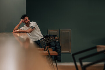young man sitting alone indoors waiting