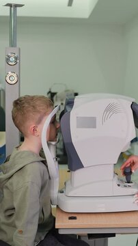 Young boy undergoing eye examination with an auto refractor