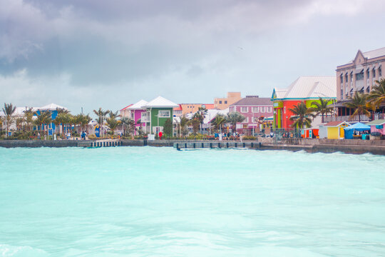 Nassau harbor with vibrant colonial houses and colorful shops along the waterfront, reflecting the lively culture and tropical charm of the Bahamas