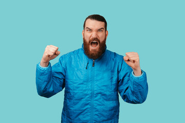 Fototapeta premium Bearded White Man Celebrating Raised Fists, Open Mouth And Intense Expression, Victory Reaction Suggesting