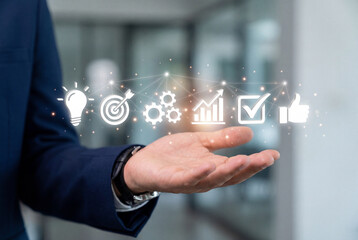 Obraz premium Hand holding a pencil pointing at icons on a digital screen for brainstorming and ideas.