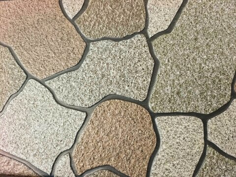 Stone wall texture. Irregular stone tile mosaic with natural colors and dark grout lines, creating textured decorative surface for flooring or walls.  
