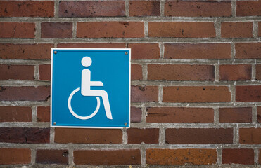 Handicaped parking sign on a brick wall.