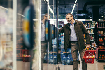 Man shopping for groceries opening a refrigerator door