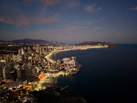 vivid coastal cityscape shining brightly as nightlife and reflections animate shoreline area