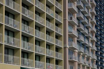 Fototapeta premium A cityscape featuring three high-rise apartment buildings with rows of balconies. The geometric patterns create a sense of rhythm and contrast.