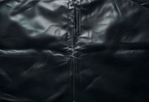 Close-up of black leather jacket zipper seam and wrinkled glossy texture