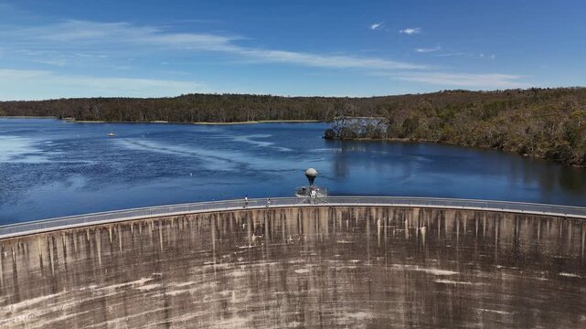 4K aerial drone footage of Whispering Wall dam, blue reservoir lake and surrounding forest landscape in Barossa Reservoir Reserve, Williamstown, South Australia
