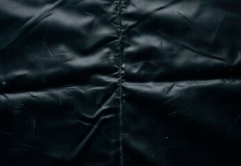 Close-up of black puffer jacket seam showing wrinkled nylon texture © DesignSells