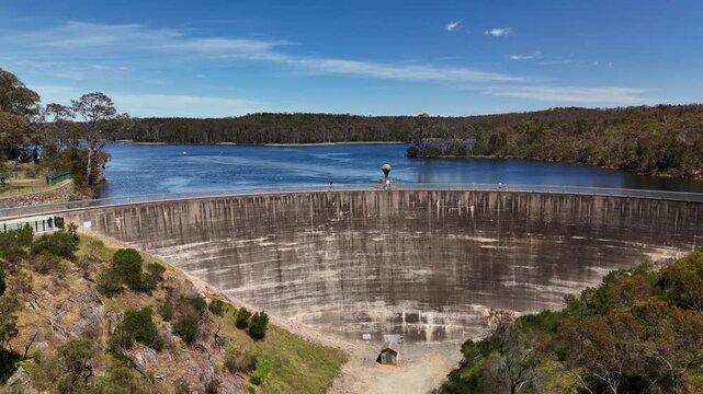 4K aerial drone footage of Whispering Wall dam, blue reservoir lake and surrounding forest landscape in Barossa Reservoir Reserve, Williamstown, South Australia