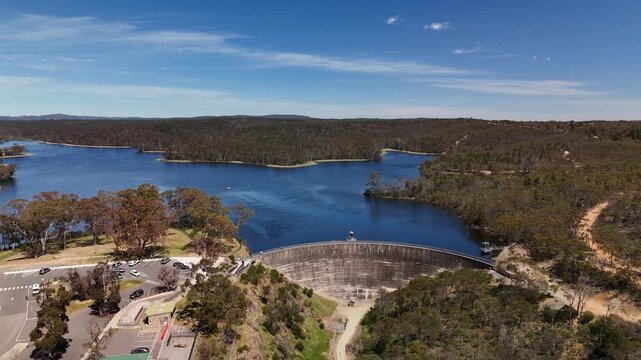 4K aerial drone footage of Whispering Wall dam, blue reservoir lake and surrounding forest landscape in Barossa Reservoir Reserve, Williamstown, South Australia