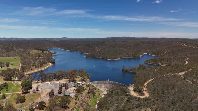 4K aerial drone footage of Whispering Wall dam, blue reservoir lake and surrounding forest landscape in Barossa Reservoir Reserve, Williamstown, South Australia