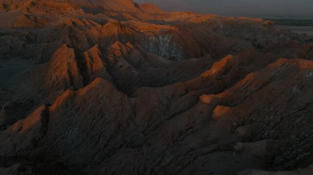 Drone view of rugged desert mountains and dry valleys in northern Chile. Erosion has sculpted dramatic patterns across the arid landscape.