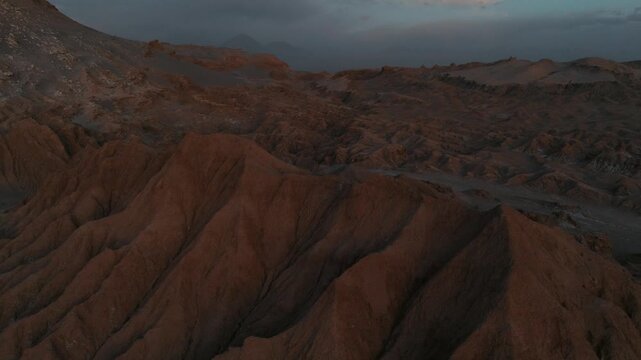 Drone view of rugged desert mountains and dry valleys in northern Chile. Erosion has sculpted dramatic patterns across the arid landscape.