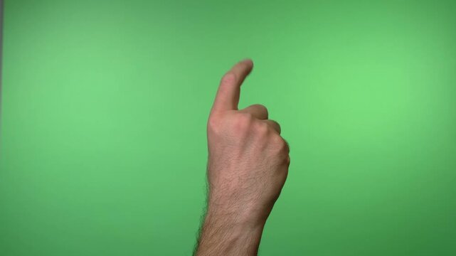 Close up video of a hand using its index finger to gesture "come here" against a solid green background for compositing.

