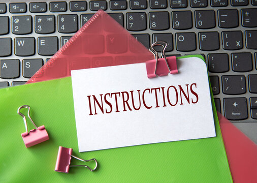 INSTRUCTIONS - word on a white sheet on a laptop background with colorful folders
