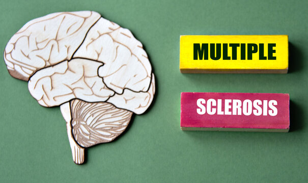 MULTIPLE SCLEROSIS - words written on wooden cubes on a green background with an image of a skull and brain.