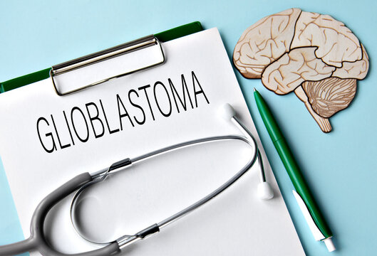 GLIOBLASTOMA - word on white sheet on blue background and skull mockup