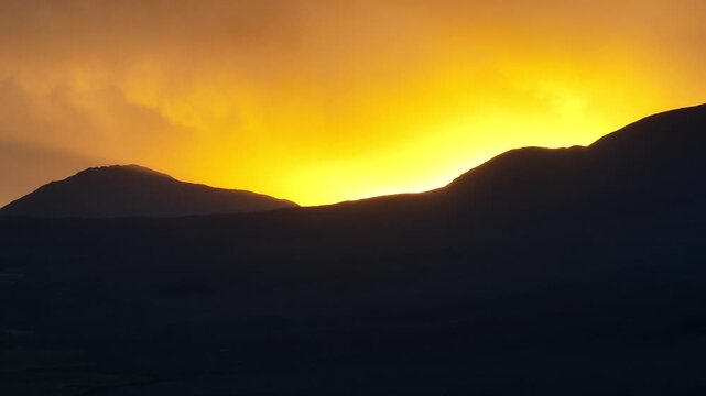 Aerial sunset over Sajama plains in Bolivia, warm golden light illuminating vast Altiplano landscape. Minimalist scenery with long shadows and dramatic sky.
