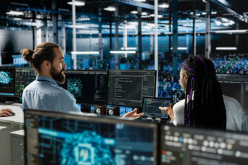 Data center team leader and intern working together on AI databases. Server room manager and...