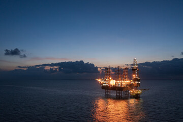Aerial view of offshore jack up rig and offshore platform during sunset for oil and gas exploration...