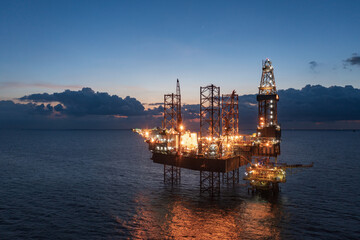 Aerial view of offshore jack up rig and offshore platform during sunset for oil and gas exploration...