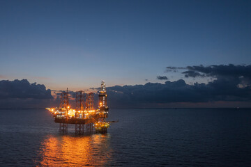 Aerial view of offshore jack up rig and offshore platform during sunset for oil and gas exploration...
