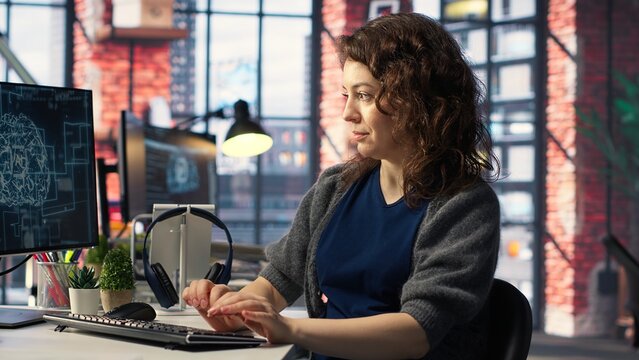IT expert writing code and debugging on artificial intelligence neural networks computerized brain model. Woman tech support doing checkup on AI systems, cloud computing. Camera B.