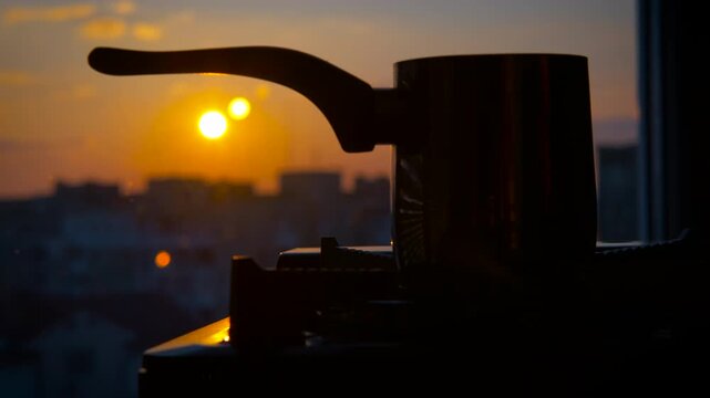 Coffee pot silhouette at sunrise: brewing a new day. Warm golden sunlight streaming through kitchen window, silhouetting coffee pot against vibrant sunrise, capturing peaceful morning brewing ritual