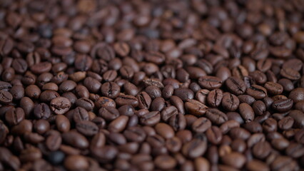 Fototapeta premium Closeup of aromatic roasted coffee beans with shiny coating, Macro shot capturing aromatic roasted coffee beans with glossy surface under warm light for marketing and packaging