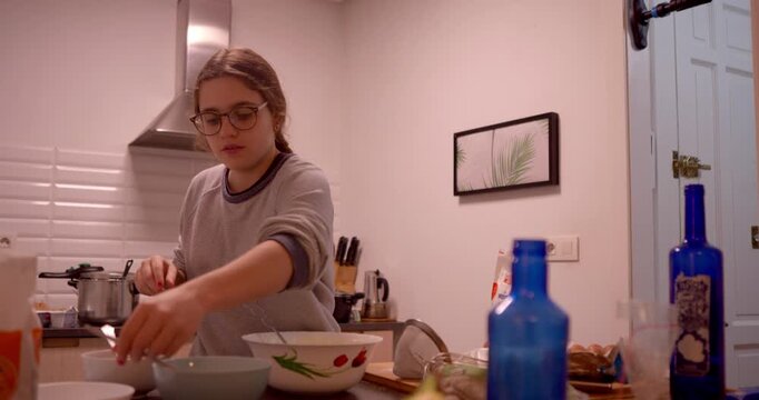 Culinary Creation: A young individual focuses intently on the art of cooking, surrounded by the essentials in a well-lit kitchen.