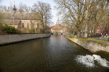 Fototapeta premium Bruges canal featuring minnewater and church of our lady spire