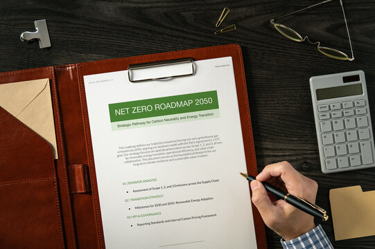 Net Zero Roadmap 2050: Realistic mock-up mock placed on  with calculator, sticky note, pen. Contributor-created fictional business document for illustrative purposes.