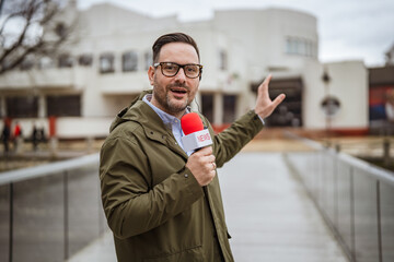 Male reporter broadcasting news live outdoors on bridge