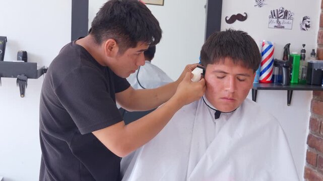 Professional barber giving a fade haircut with electric clipper