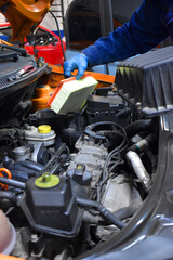 Obraz premium Mechanic repairing car engine in auto workshop