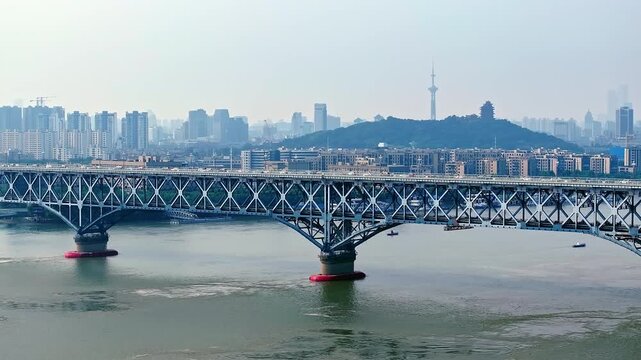 Nanjing Yangtze River Bridge crossing the Yangtze River with city skyline and TV tower in Nanjing, China.