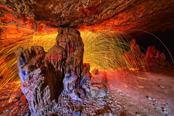 Steel Wool Sparks and Graffiti on Rock Columns in Colorful Cave Interior