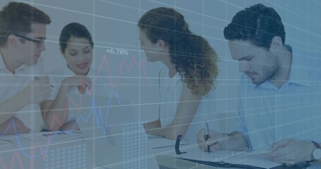 Discussing five staff in shirts leaning toward laptop in office under chart overlay, writing binder