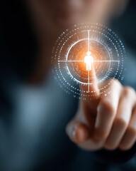 Obraz premium Targeted Focus: A hand delicately interacts with an illuminated digital interface, highlighting a person icon within a precise targeting reticle, signifying precision and focus.