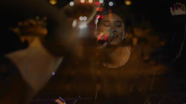 LEDs turning on causing singer singing into mic crowd raising phones road lights making night vibe
