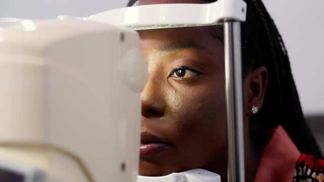 African woman having her eyes examined with a non-contact tonometer (NCT) for optical health