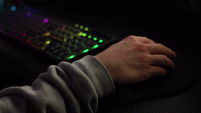 Main utilisant clavier RGB et souris dans un setup gaming sombre &ndash; vid&eacute;o 4K

