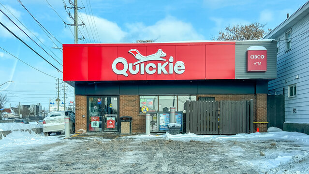 Quickie convenience store exterior with snow-covered ground and CIBC ATM visible, located in a suburban area with power lines in the background