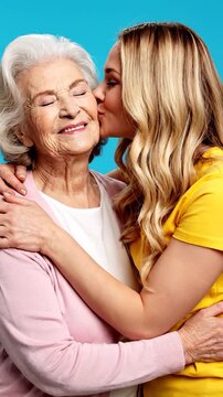 A younger woman hugs and kisses an older woman with affection