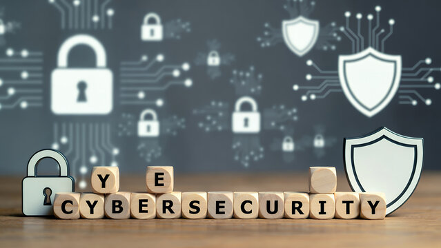 Wooden blocks spell 'CYBERSECURITY' with shield and padlock symbols for digital protection.