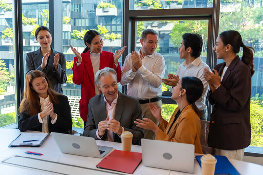 Multiracial euphoric business team people give high five at office table with laptop, happy excited diverse work group engaged in teambuilding celebrate corporate success win partnership power.teamwor