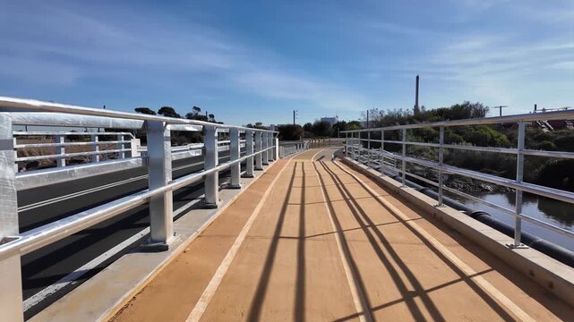 Pedestrian and cycling path separated from roadway by safety railings on a modern bridge in Melbourne, Australia. Dedicated active transport infrastructure with protective barriers for safe travel