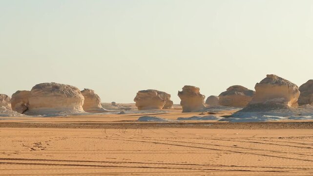 Driving past sculpted limestone rocks in White Desert National park at golden hour