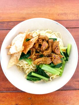 Indonesian Bakso Meatball Noodle Soup in White Bowl on Wooden Table